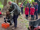 William and Kate the happy campers! Prince and Princess of Wales help children prepare food around a campfire as they visit primary school on latest royal trip