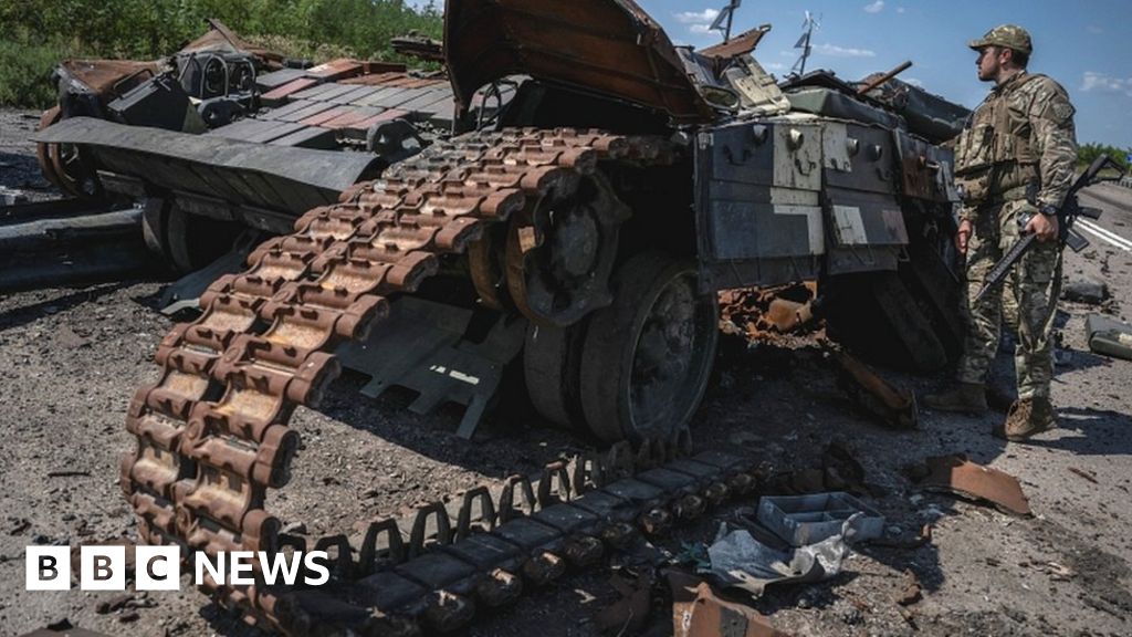 Ukrainian soldier examining wreckage of tank, near the village of Robotyne, 25 August 2023