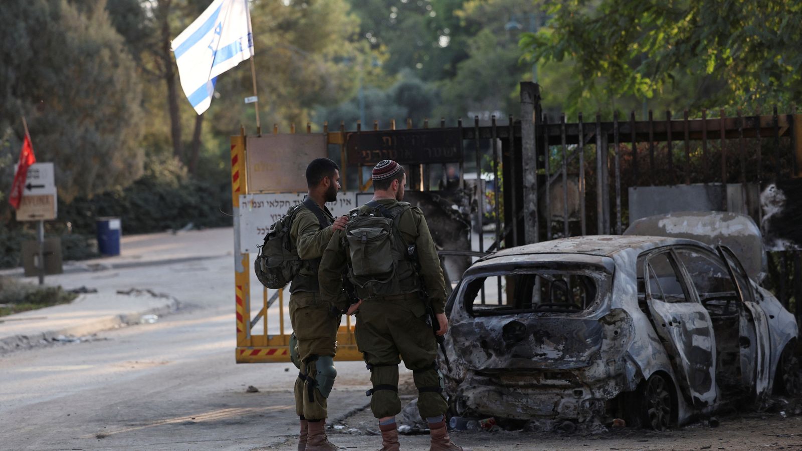 Israeli soldiers stand at the entrance to kibbutz, in the aftermath of a mass infiltration by Hamas gunmen from the Gaza Strip, in Kibbutz Beeri in southern Israel, October 14, 2023. REUTERS/Violeta Santos Moura