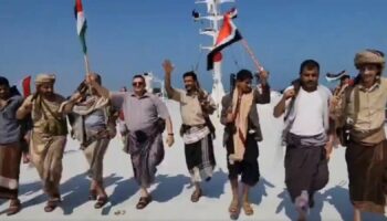 Men carrying flags and rifles are seen dancing on the deck in the video