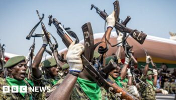 Soldiers with the People's Revolutionary Armed Forces (FARP) hold their guns in the air during Guinea-Bissau's 50th Independence Day celebrations in Bissau on November 16, 2023. (