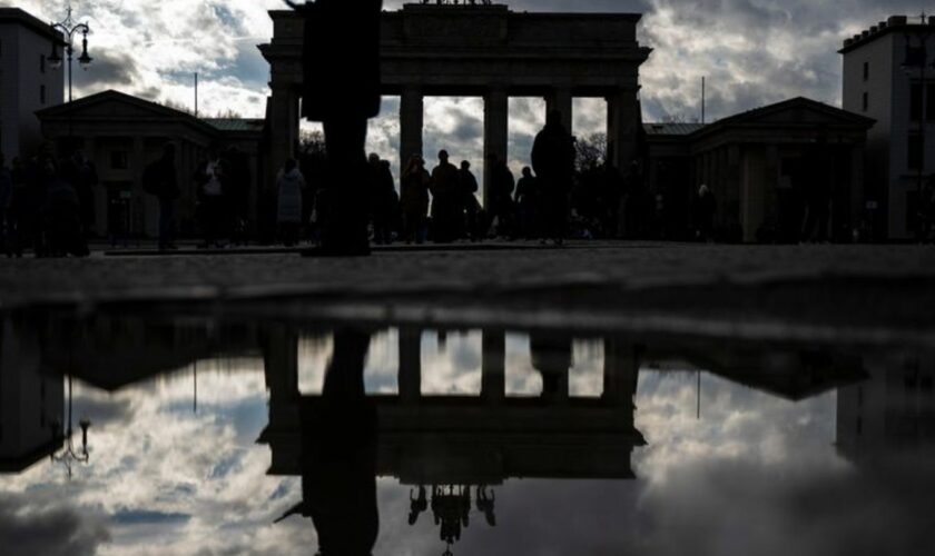 Das Brandenburger Tor spiegelt sich nach dem Regen in einer Pfütze. Foto: Monika Skolimowska/dpa